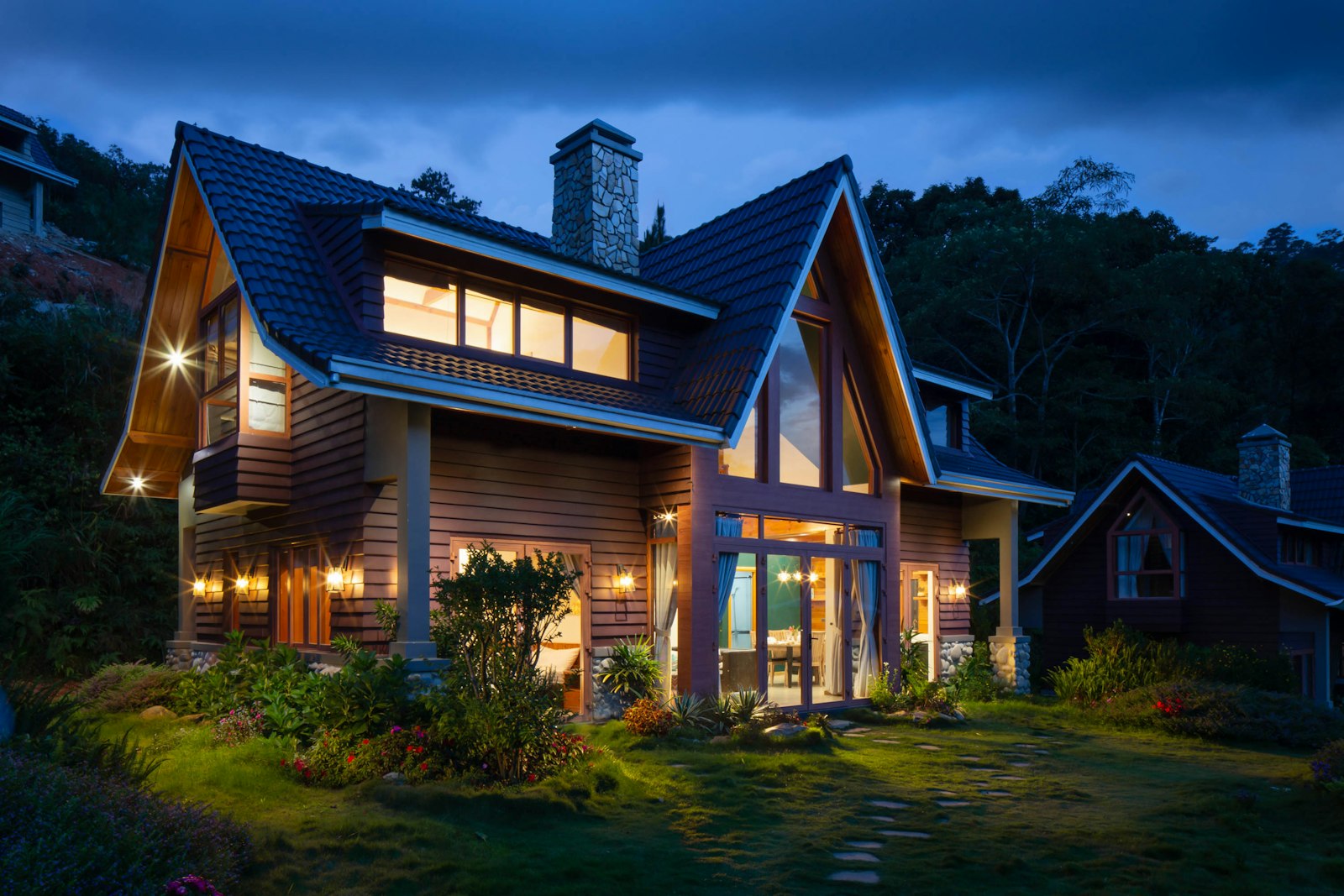 a beautiful home at dusk with warm lit windows