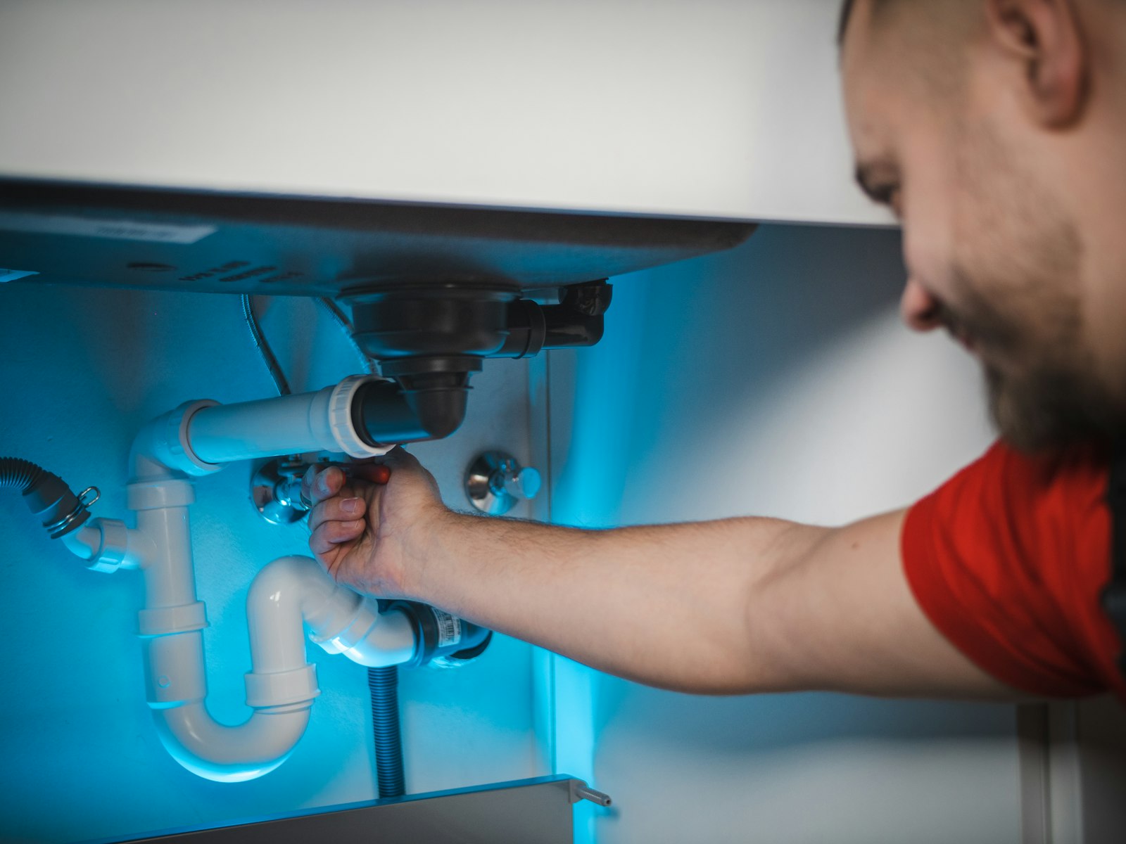 a plumber fixing a kitchen sink